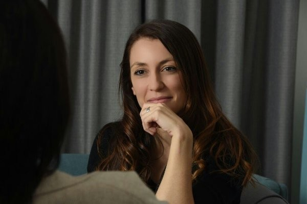 Rachel, registered psychologist and founder of Embodiment Psychology, seated in conversation, offering a warm and attentive expression.